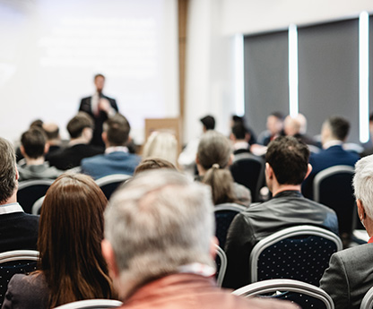 Attendees sit at a conference presentation