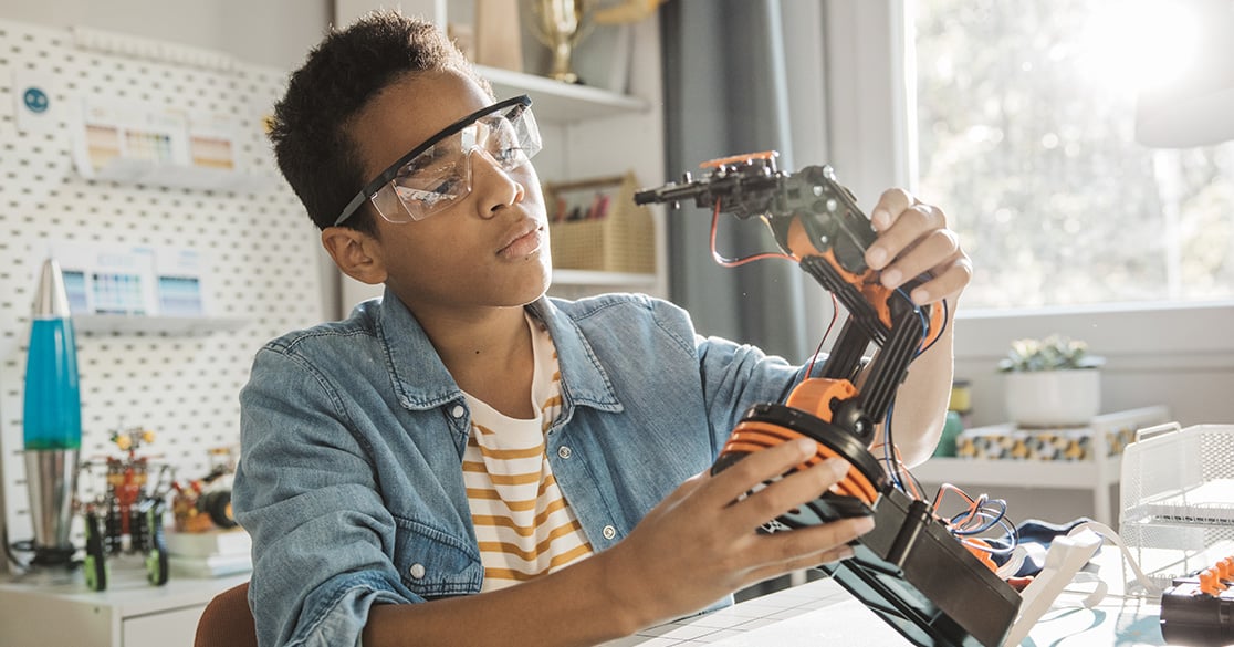 From Roadblocks to Results: Join FlexPoint at ACTE’s CareerTech VISION Conference Student assembling a robotic arm at a desk with tools and parts in a bright, modern learning space.