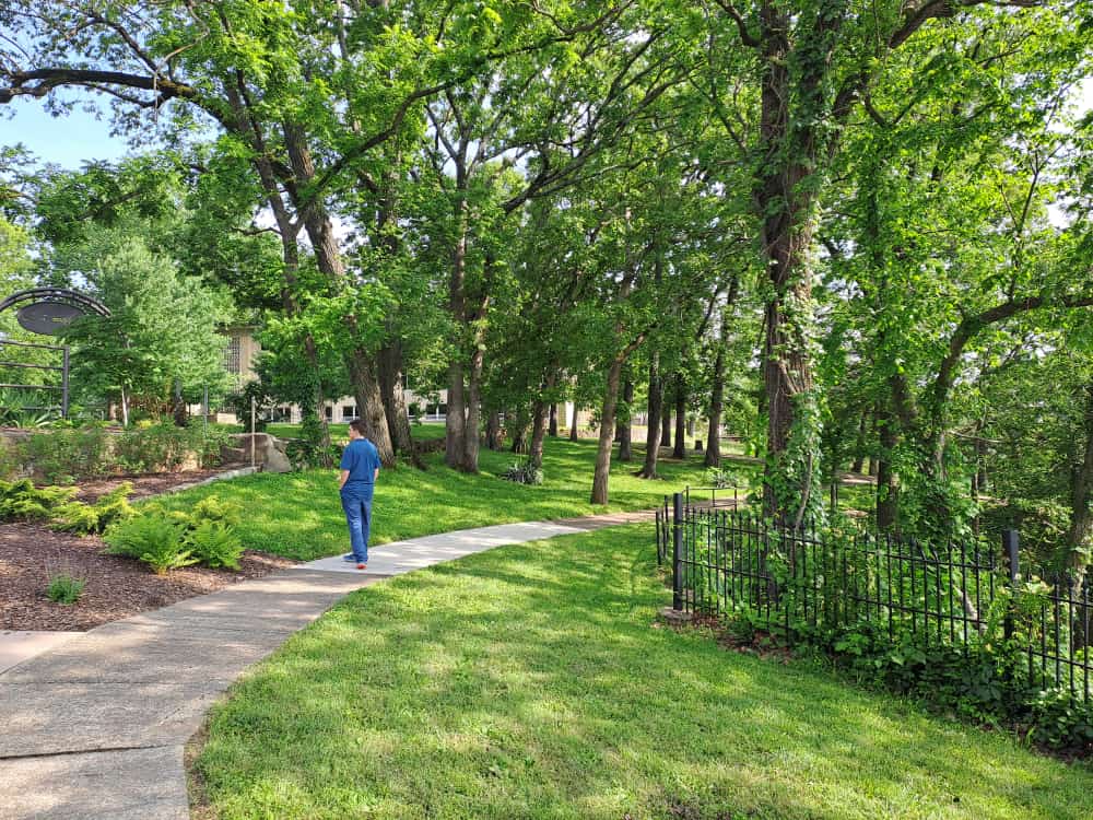 Thrive school student, Waldo, at College of the Ozarks surrounded by trees