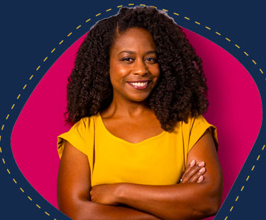 Teacher smiling in a yellow shirt with her arms crossed